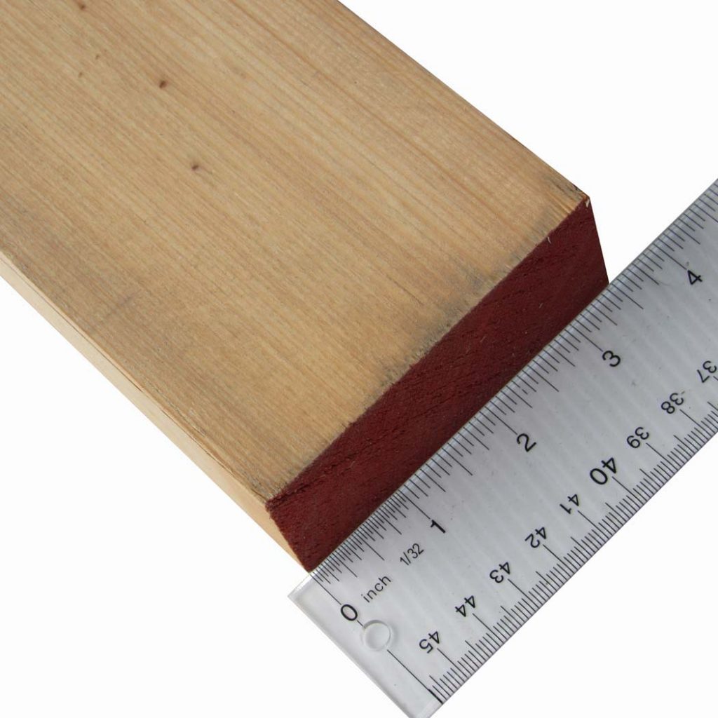 2x4 board with ruler showing actual lumber dimensions vs nominal
