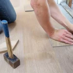 Picture of a person installing veneer wood flooring after learning about what is veneer wood?