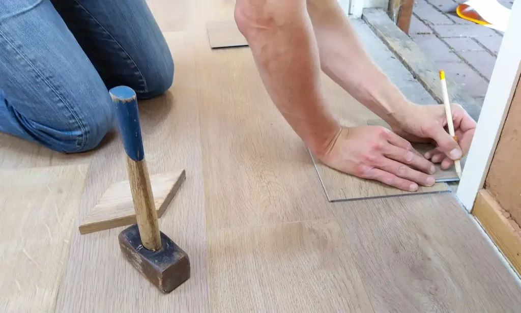 Picture of a person installing veneer wood flooring after learning about what is veneer wood?